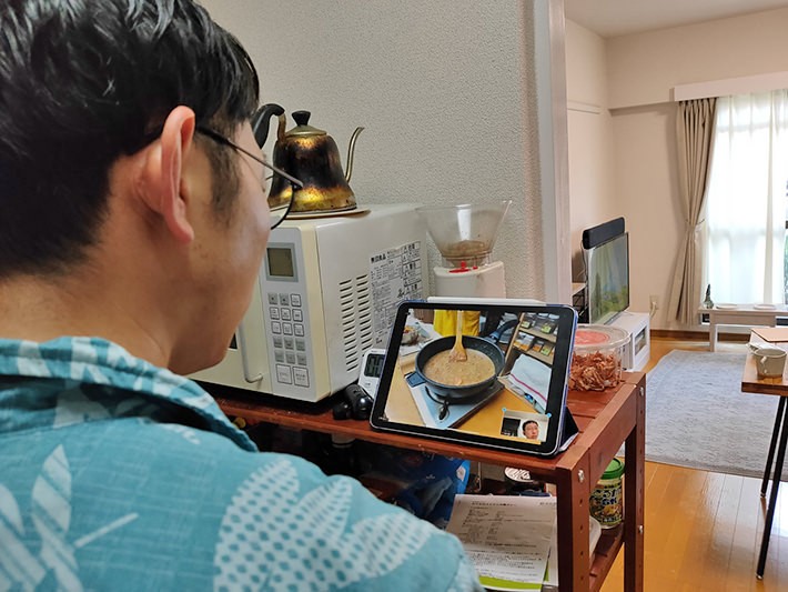 Zoomを見ながら料理をしている写真