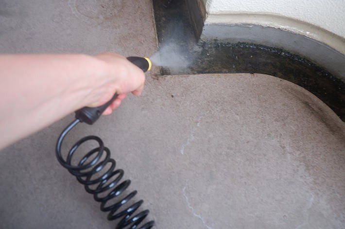 高圧洗浄機で思いっきり水を拭きかけている様子