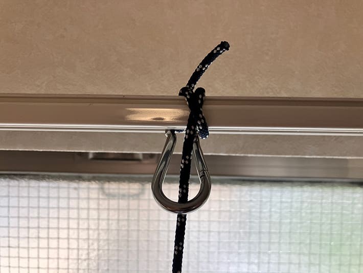 窓掃除ロボット「HOBOT」カーテンレールに固定している画像