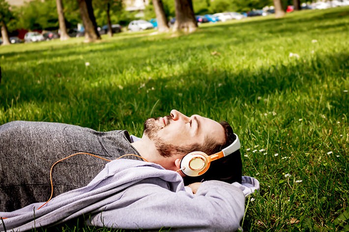 外で音楽を聴く男性